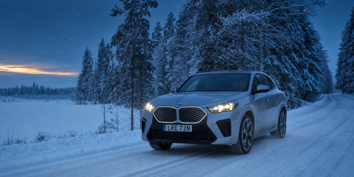 Silverfärgad BMW iX2 på snöig vinterväg