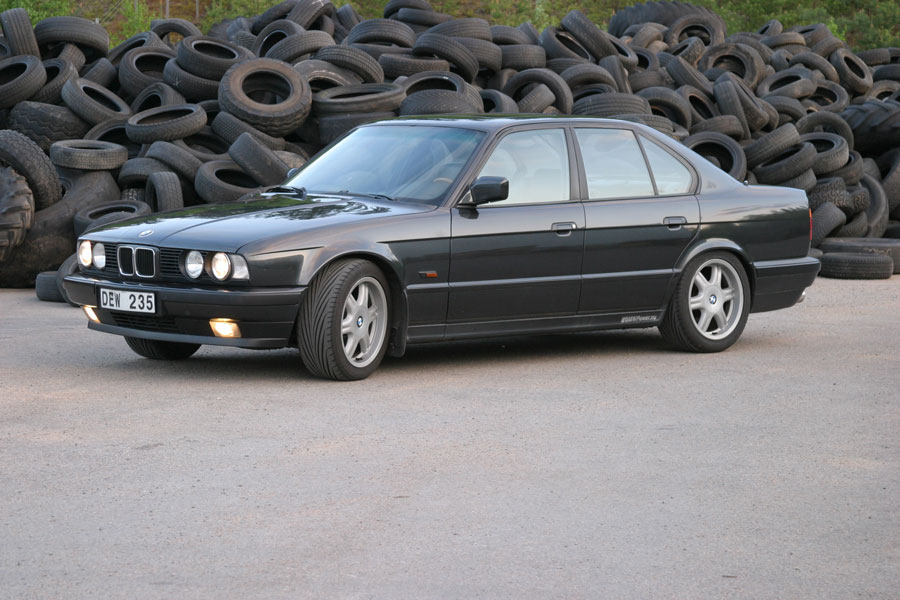 BMW fotograferad framför hög med skrotade däck