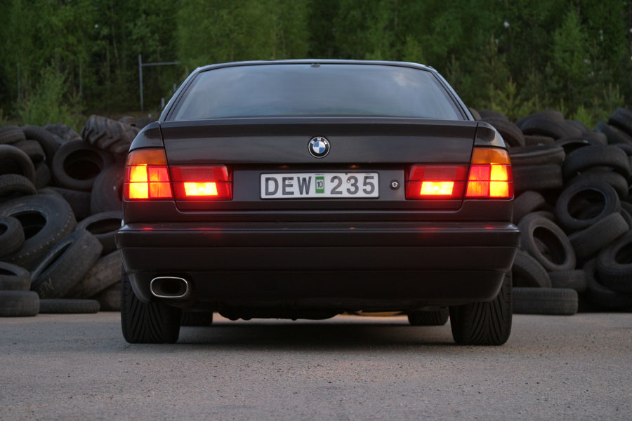 BMW bakifrån i skymningsljus med tända bromsljus