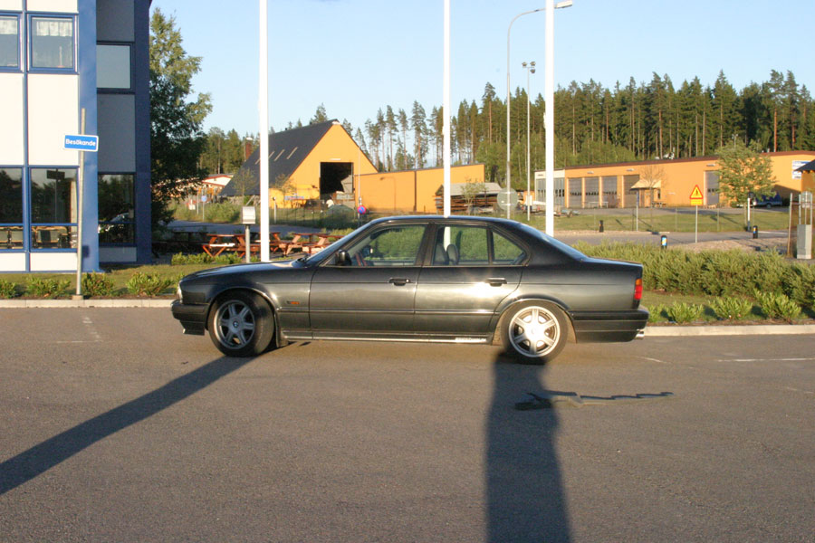 BMW parkerad med lyktstolpar och byggnader som sticker upp i bakgrunden