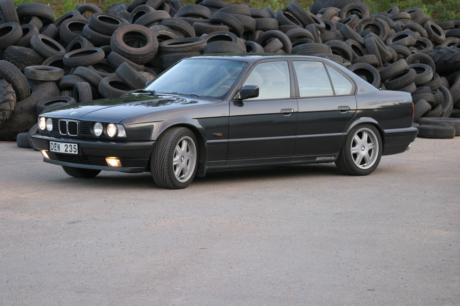 BMW i tre-kvarts vinkel framifrån med tända lyktor i skymning