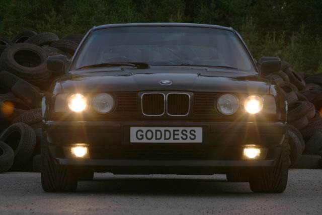 BMW framifrån i skymning med registreringsskylt retuscherad till GODDESS