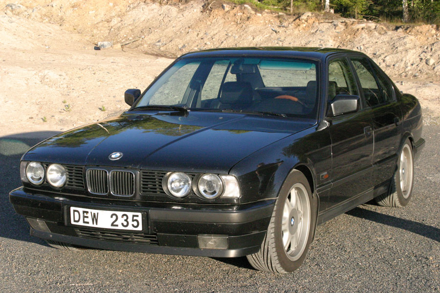 BMW framifrån i solljus med fotografens skugga synlig i förgrunden