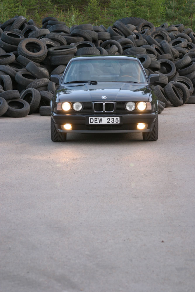 BMW framifrån i skymning med tända lyktor