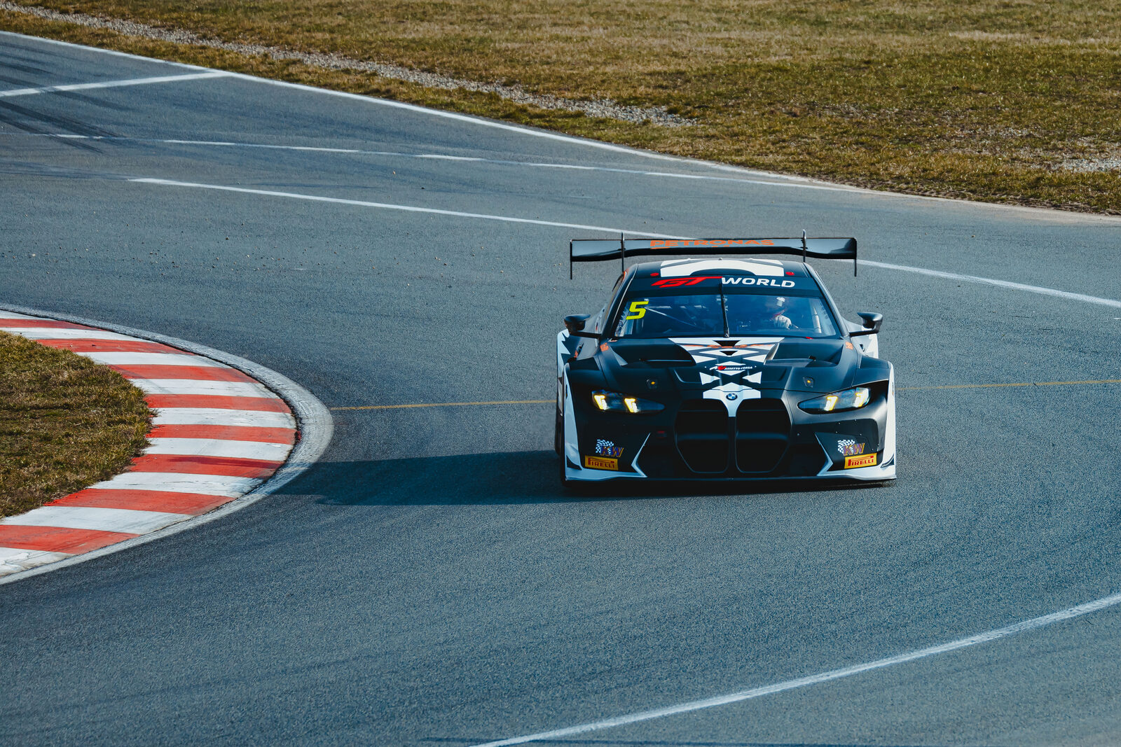 BMW M4 GT3 EVO BLEACH framifrån i kurva