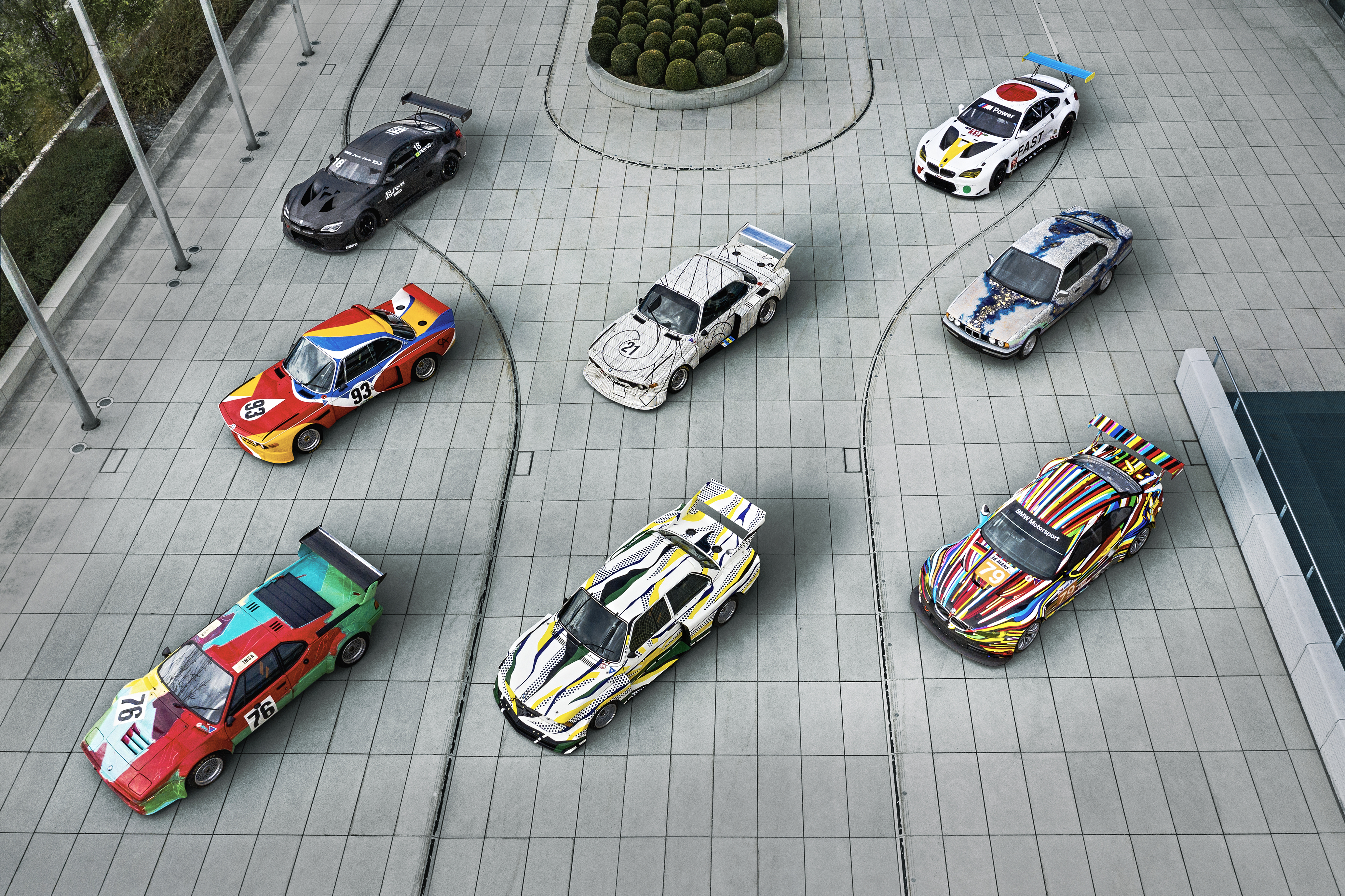 Flygfoto ovanifrån av BMW Art Cars uppställda på torget vid BMW Welt