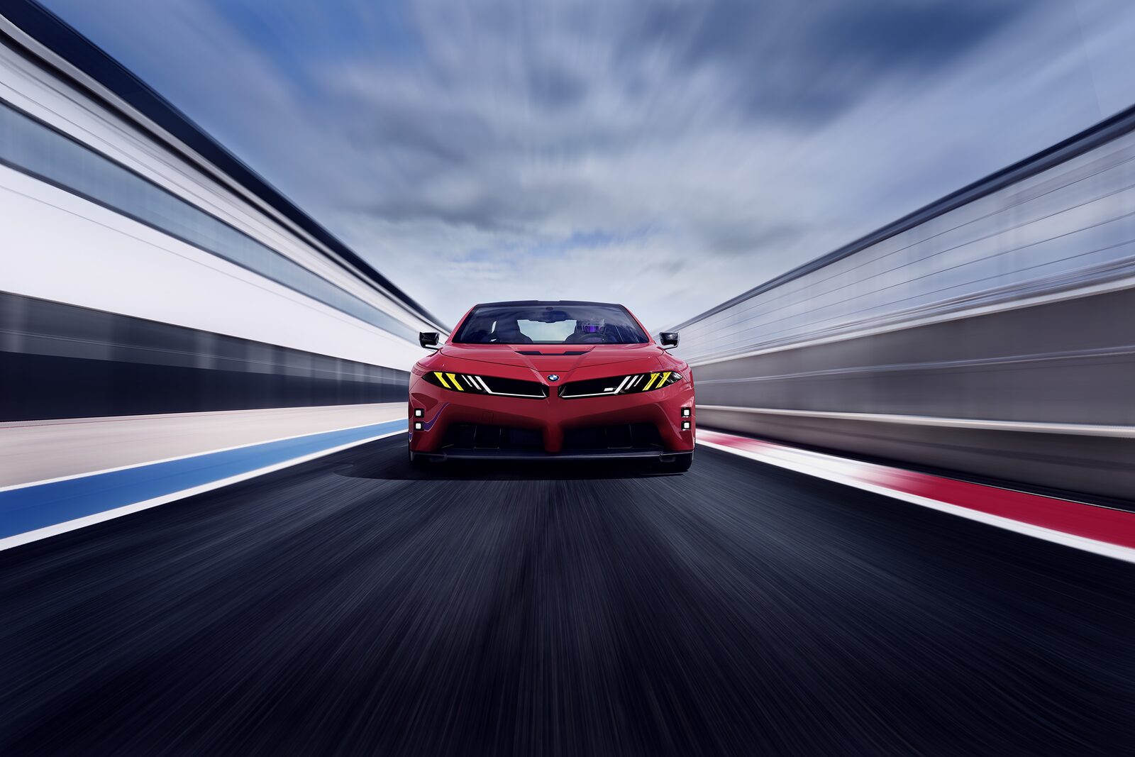 BMW M Concept Neue Klasse framifrån i fart på bana, med shark nose, M Yellow Lights och röd lack