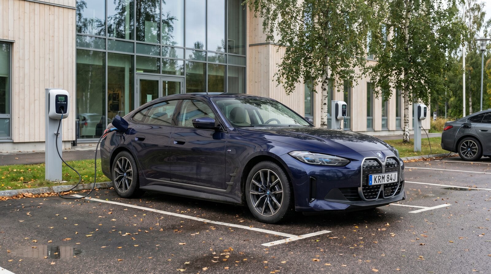 Modern elektrisk BMW laddar vid en kontorsparkering