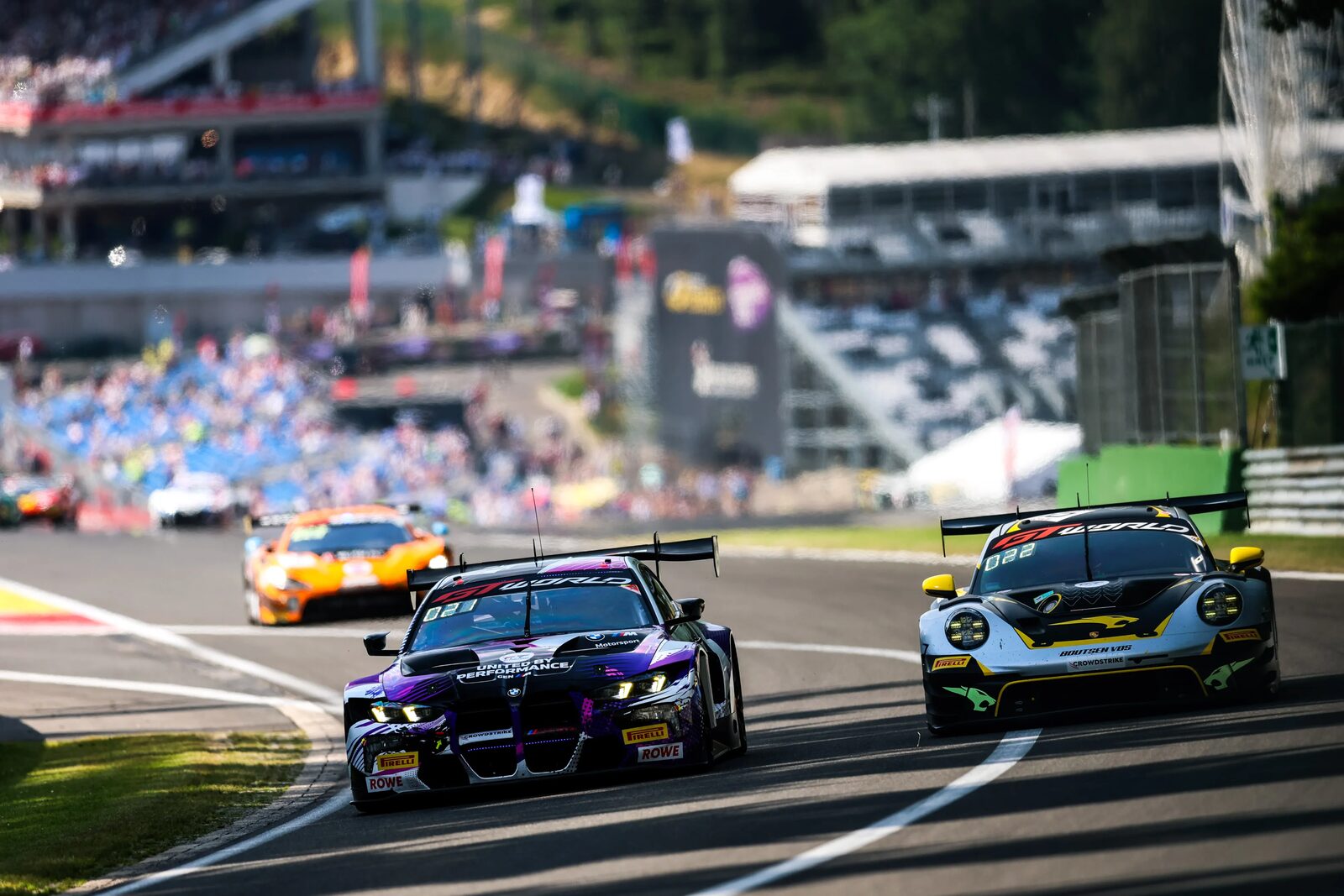 Den lila BMW M4 GT3 EVO i tät kamp med en Porsche på Spa-Francorchamps
