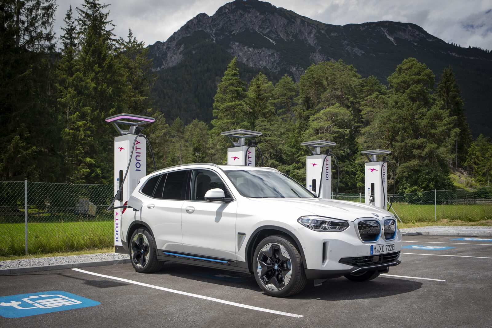 BMW iX3 laddar vid en IONITY-station med bergen i bakgrunden