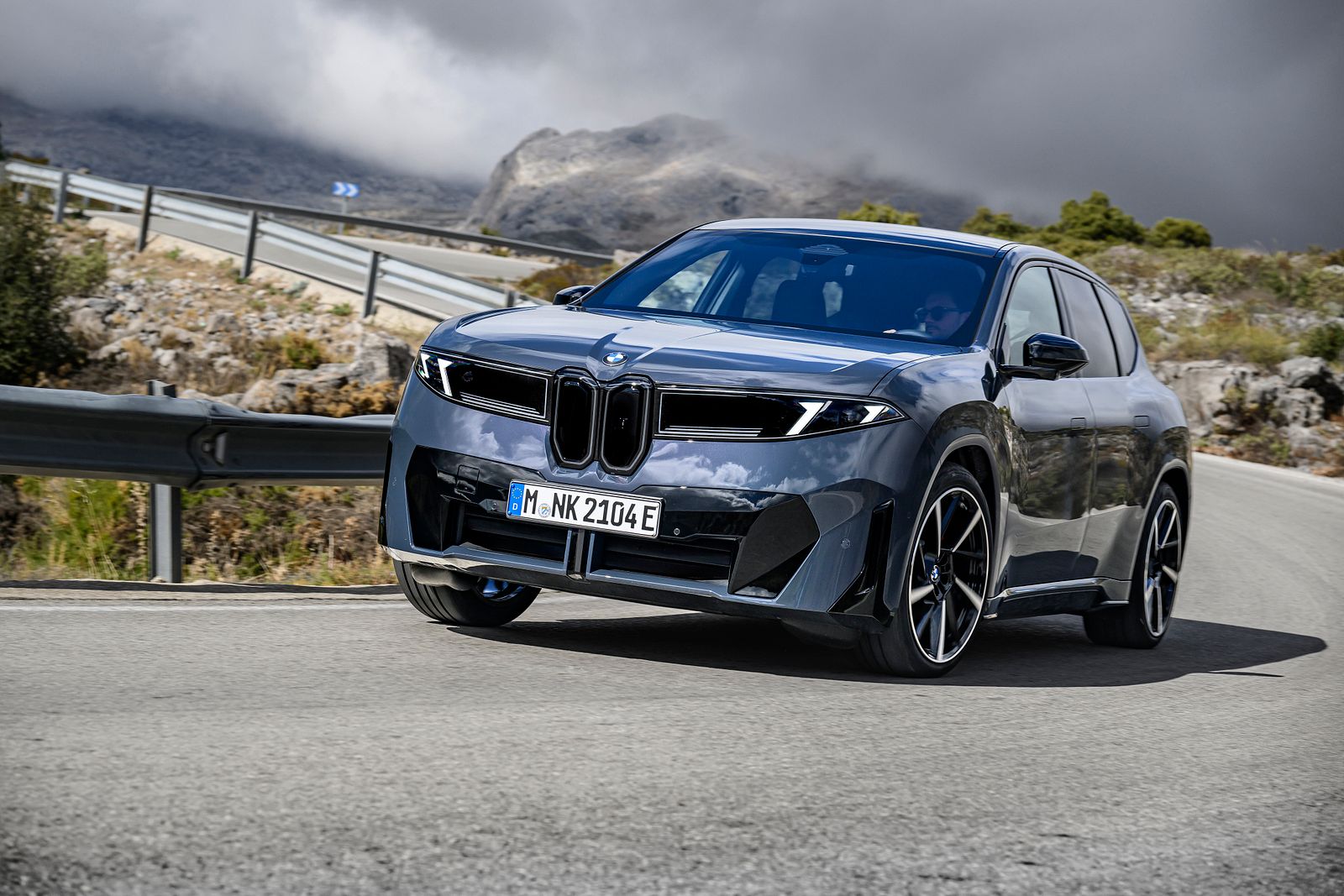 Grå BMW iX3 Neue Klasse i fart på en bergsväg