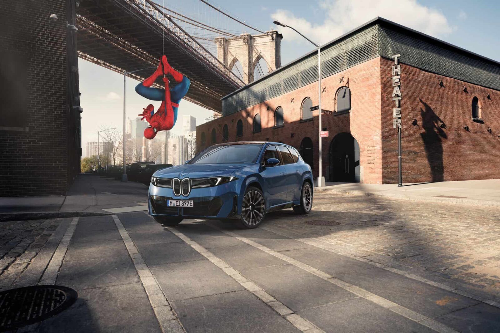 Blå BMW iX3 vid Brooklyn Bridge med Spider-Man hängande upp och ned i en tråd