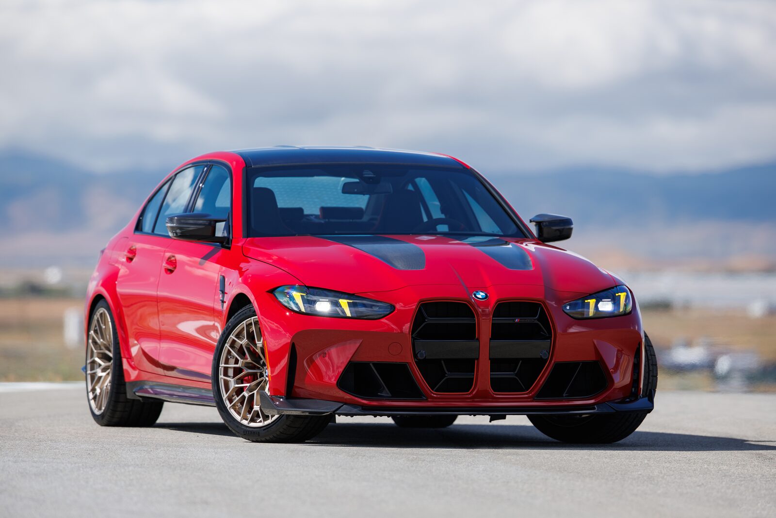 Röd BMW M3 CS Handschalter i trekvartsvy framifrån på racerbana