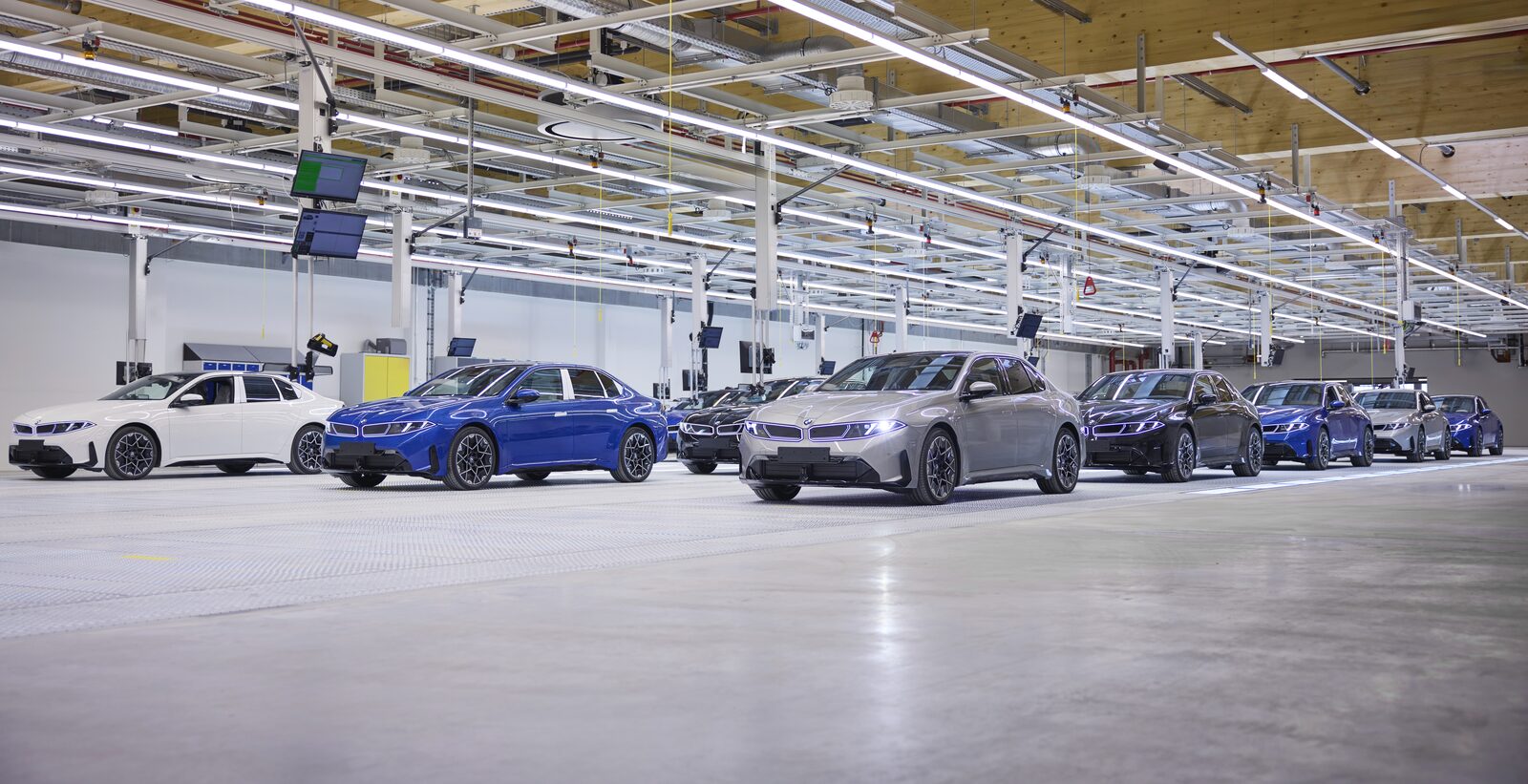 Rader av nybyggda BMW i3 i olika färger i monteringshallen på BMW Plant München