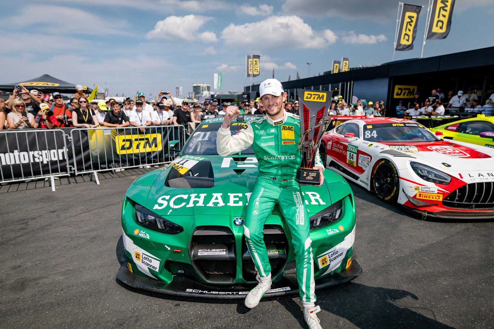Marco Wittmann poserar med segertrofén framför sin gröna Schaeffler BMW M4 GT3 EVO i parc fermé