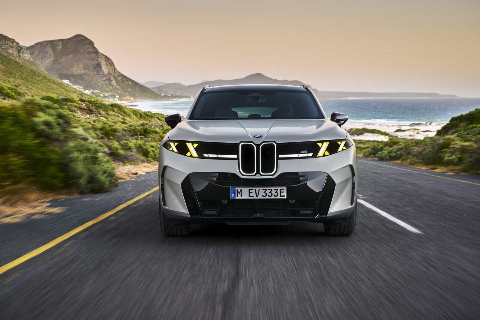 BMW X5 G65 i vitt fotograferad framifrån under körning på kustväg