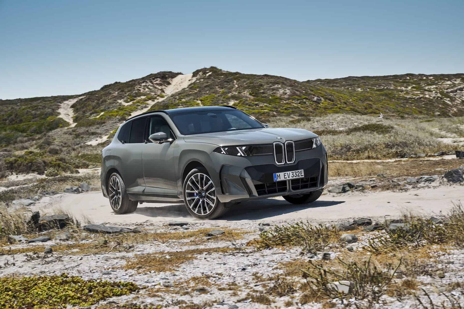 BMW X5 G65 i grått stående i trekvartsvy på ett kustlandskap