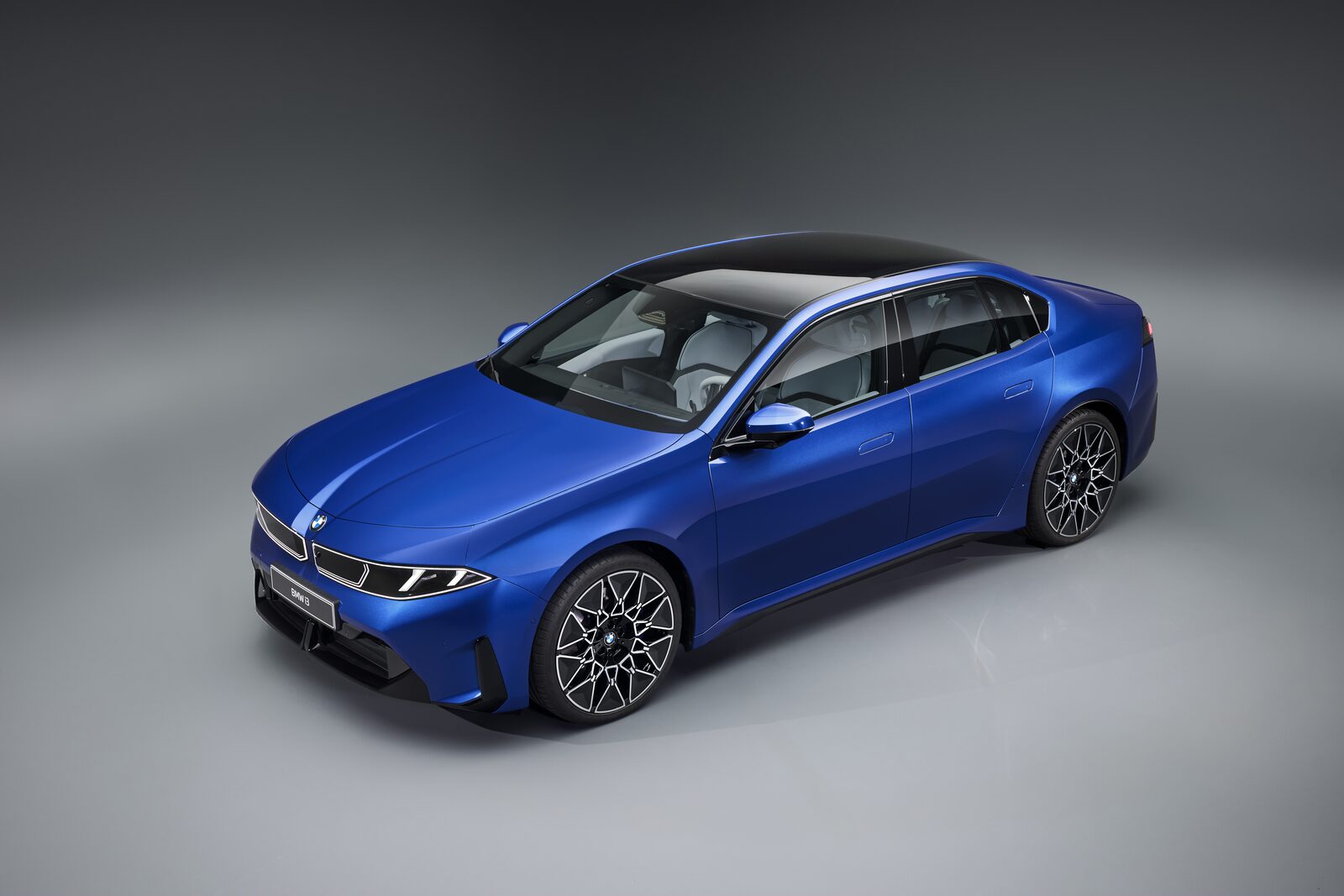 Blå BMW i3 sedan fotograferad snett framifrån i studio