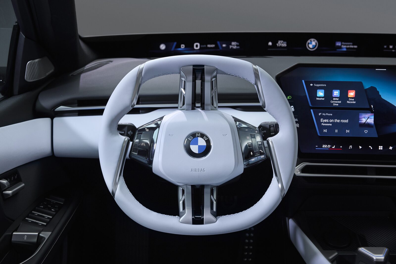 Interiör i BMW i3 med ratt i två ekrar och panoramaskärm längs vindrutan