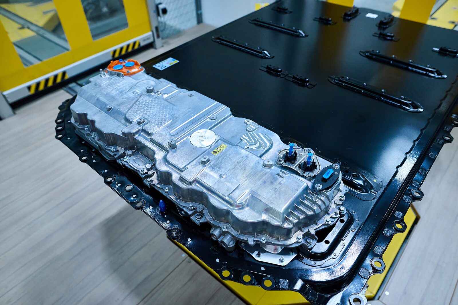 Öppet Gen6-batteripaket med drivenhet monterad ovanpå, sett uppifrån i fabriksmiljö