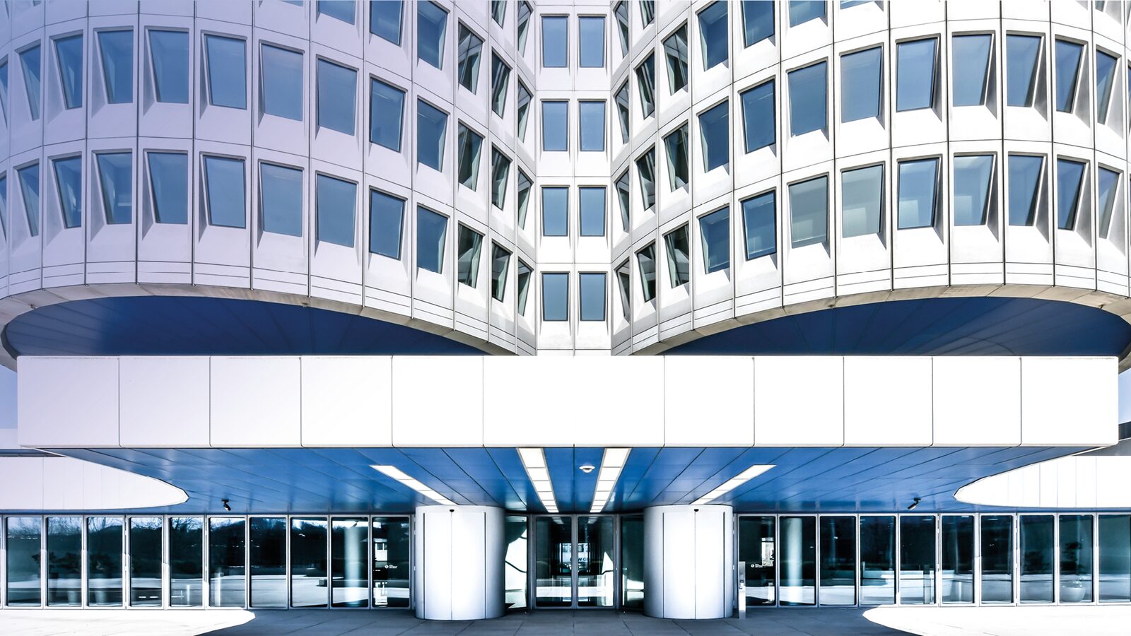 Kontorsfasaden på BMW:s huvudkontor i München med rader av fönster ovanför entrén