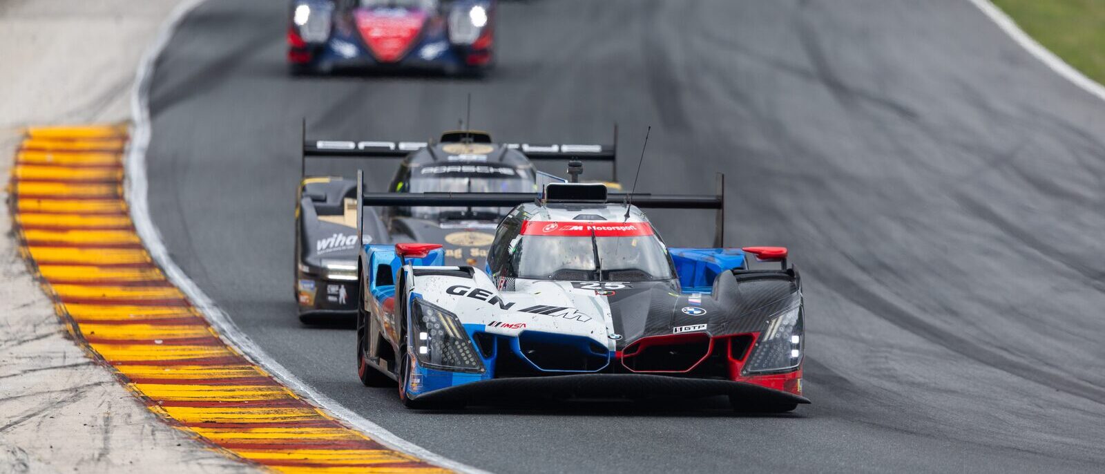 BMW M Hybrid V8 leder ett fält racerbilar genom en kurva på Road America