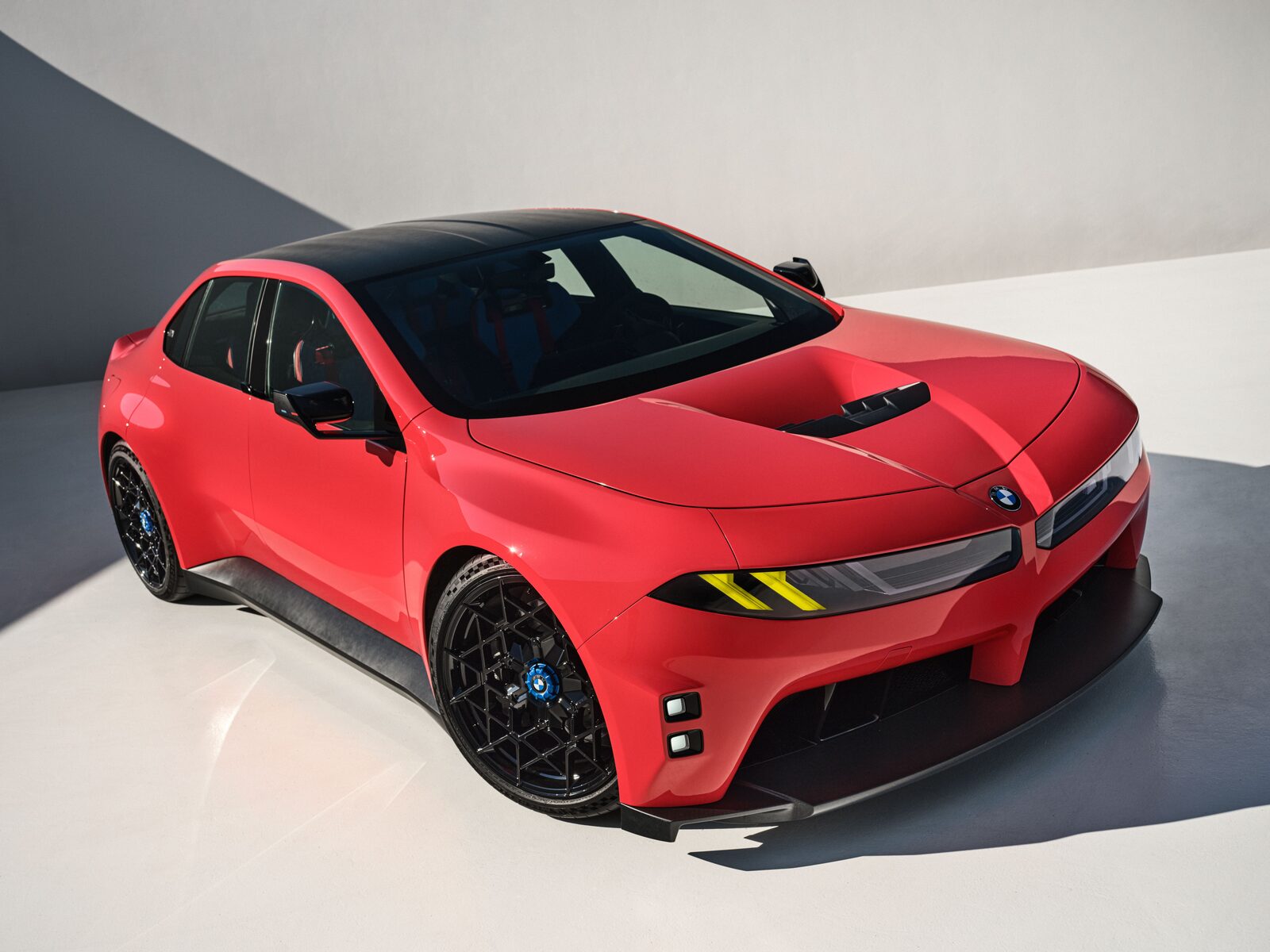 Röd BMW M Concept Neue Klasse i studio, sedd snett framifrån