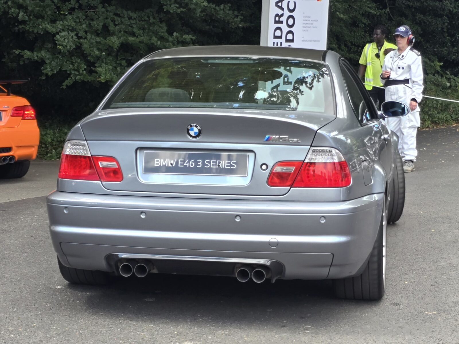 BMW M3 CSL i grå lack sedd bakifrån med CSL-diffusor och dubbla avgasrör på en gräsplan