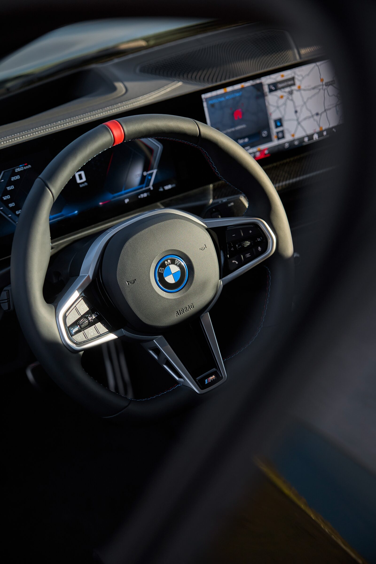 Förarplatsen i BMW i4 M50 med M-ratt och böjd dubbelskärm bakom