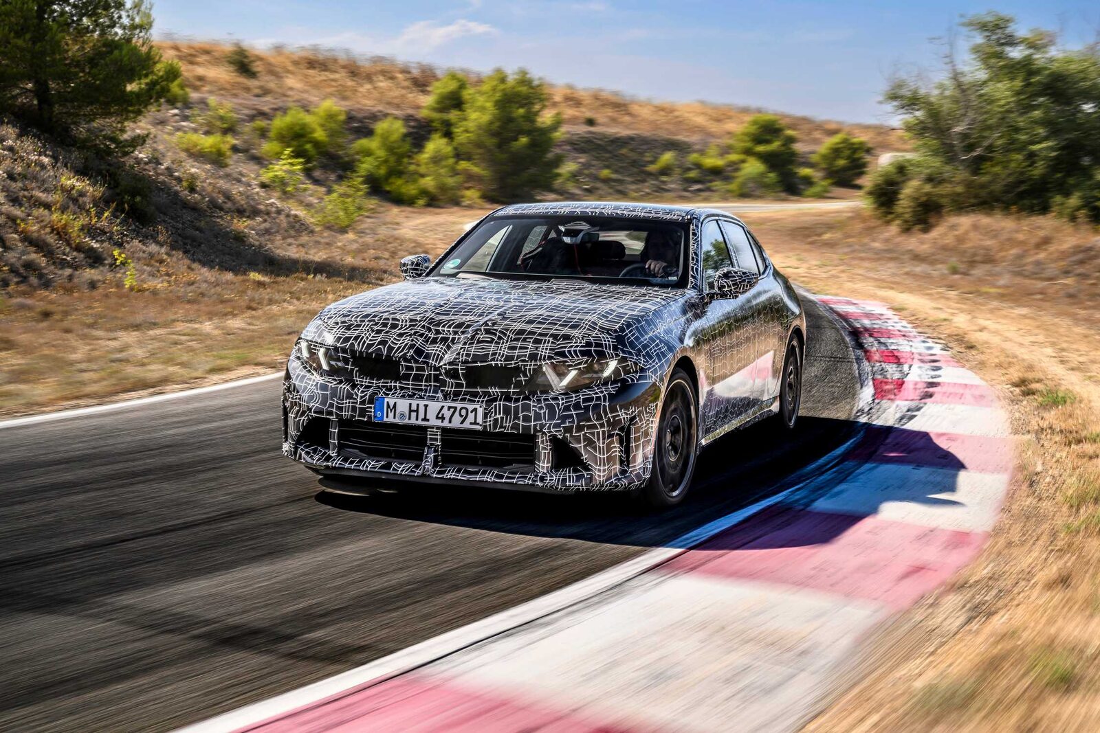 Kamouflerad BMW 3-serie-prototyp svänger över kerben på testbanan i Miramas