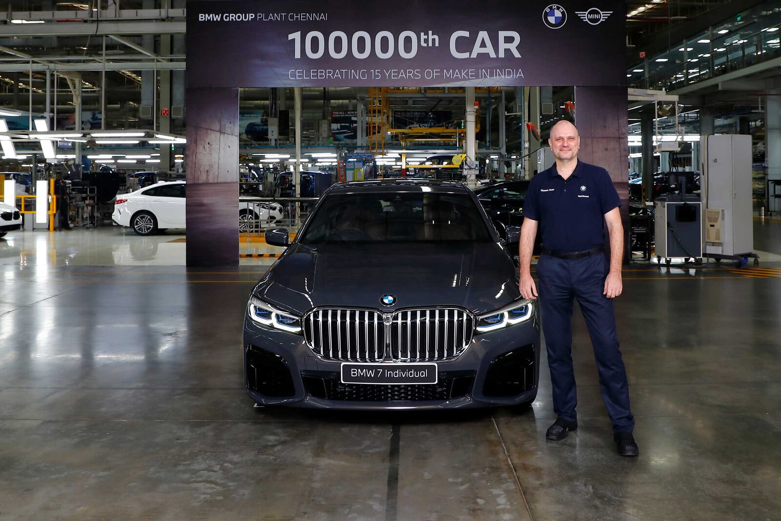 Mörkgrå BMW 7-serie i monteringshallen i Chennai under en banderoll med texten 100000th CAR