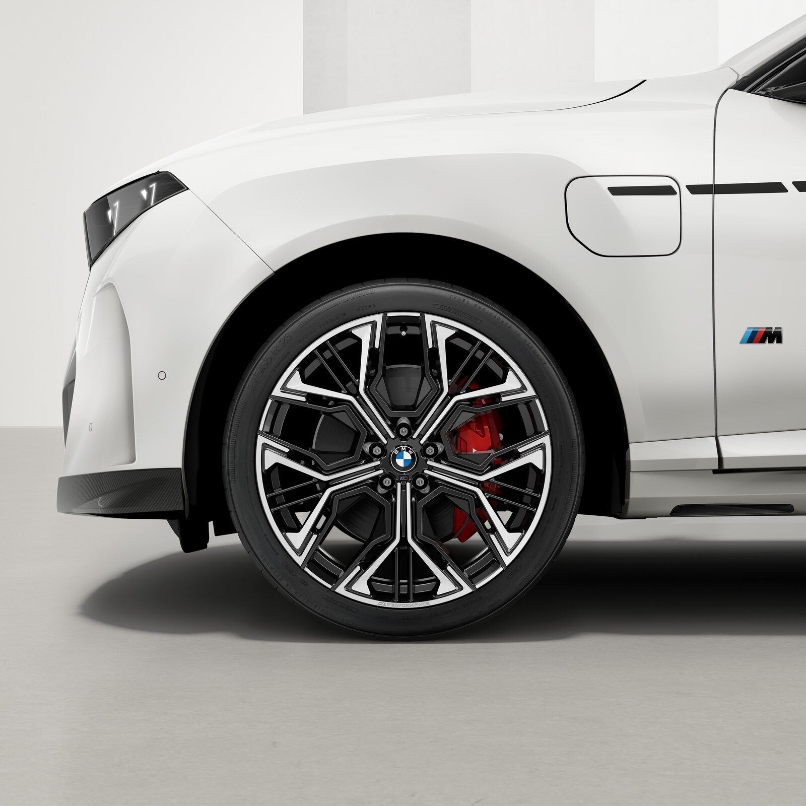 Framhjul på vit BMW X5 med 23-tums M Performance-fälg i bicolor och röda bromsok