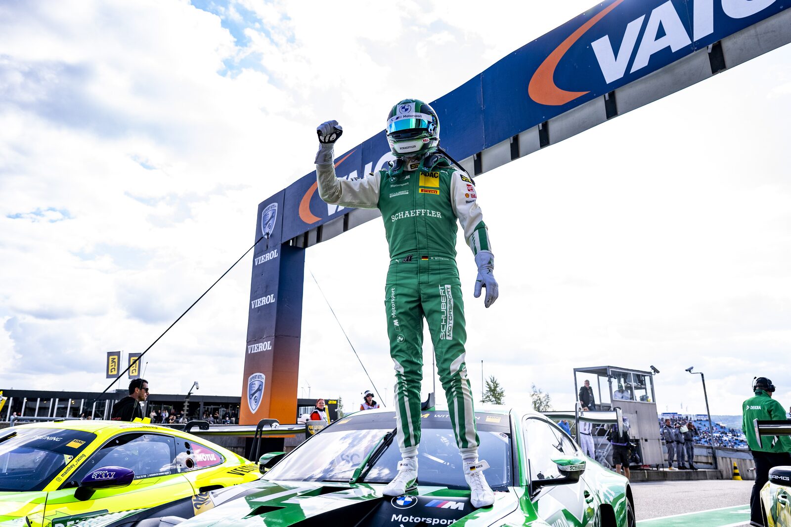 Marco Wittmann står uppe på taket av sin BMW M4 GT3 EVO under målportalen med knuten näve i luften