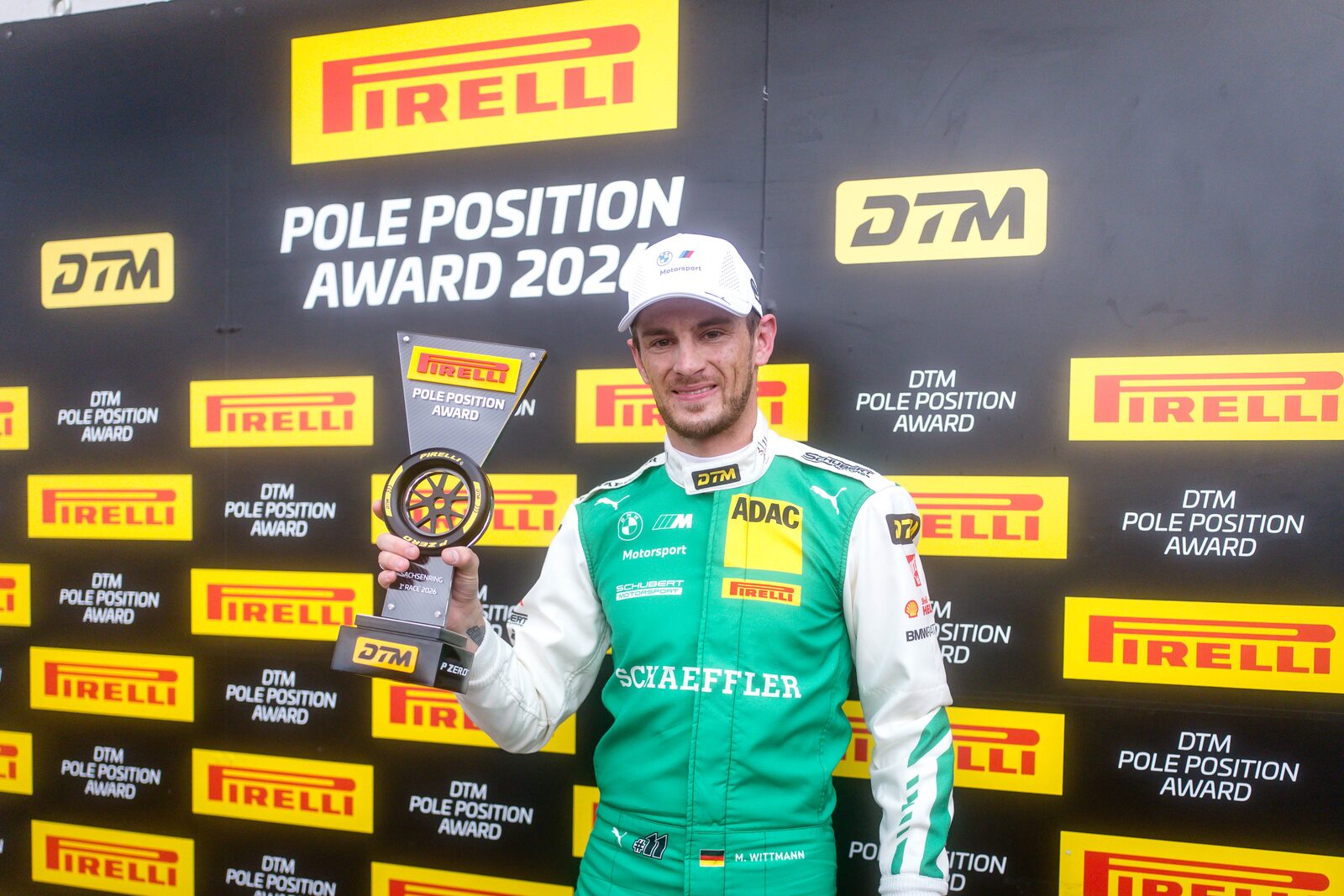 Marco Wittmann håller upp Pirelli Pole Position Award framför en sponsorvägg med DTM- och Pirelli-logotyper
