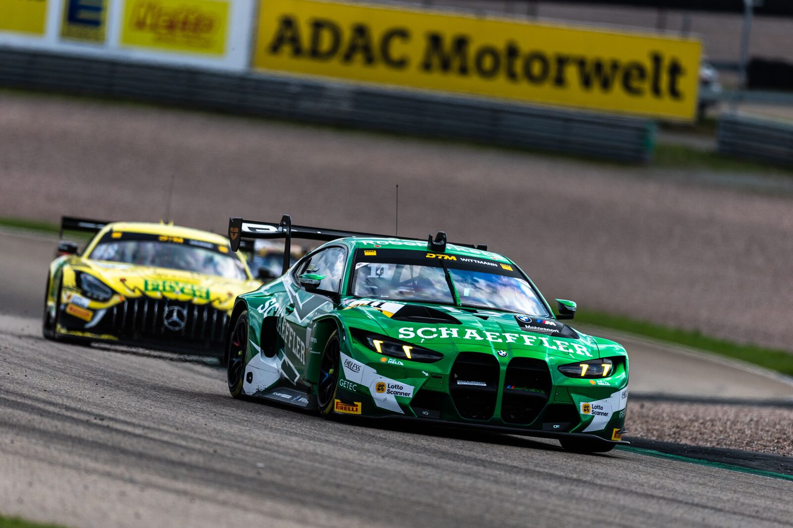 Den gröna BMW M4 GT3 EVO:n leder en gul Mercedes-AMG genom en kurva på Sachsenring