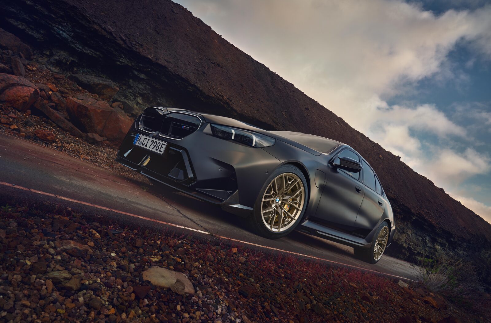 Mörkgrå BMW M5 med nya 1075 M-fälgar i Gold Bronze på en bergsväg