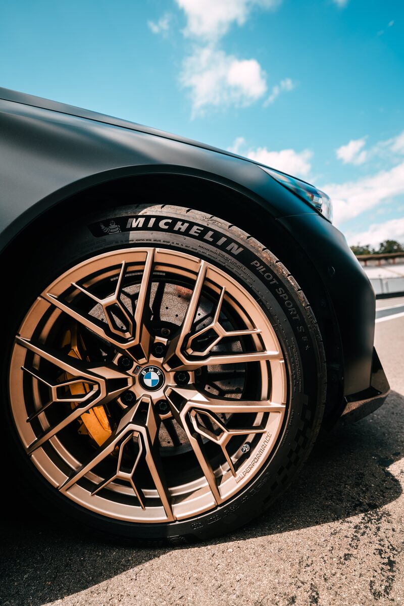 Närbild på en 1075 M-fälg i Gold Bronze med Michelin-däck på en mörkgrå BMW M5
